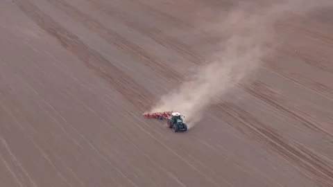 Aerial View of a Farm Tractor Operating a Cultivator in a Field Stock Footage 273894300