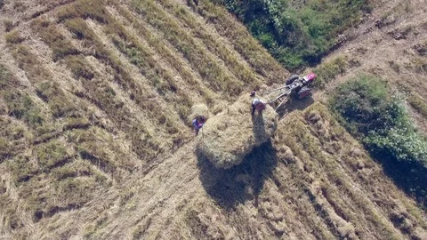 Aerial view of farmer loading stack of hay on top of a tractor trailer Vídeos de archivo 122044640