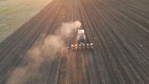 Aerial view of Farmer with old tractor seeding sowing crops at agricultural Stock Footage 153817062
