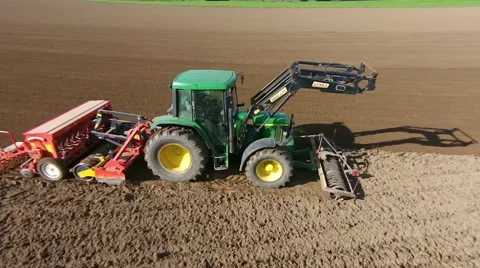 Aerial view of a farmer sowing wheat on a huge field with his tractor. Stock Footage 43065414