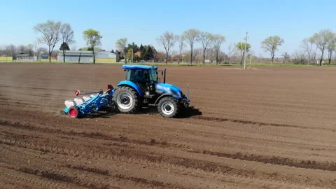Aerial view of a farmer in tractor seeding corn Stock Footage 148174147
