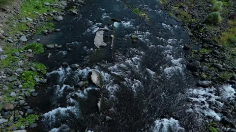 Aerial view of a fast river with rocky banks and green moss. Stock Footage 336852554