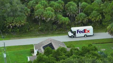 Aerial view of Fedex white delivery truck driving on suburban street delivering Stock Footage 309146428