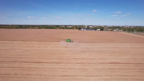 Aerial view of a field as advancing towards the farmer as he Harvests his crop Stock Footage 219087210