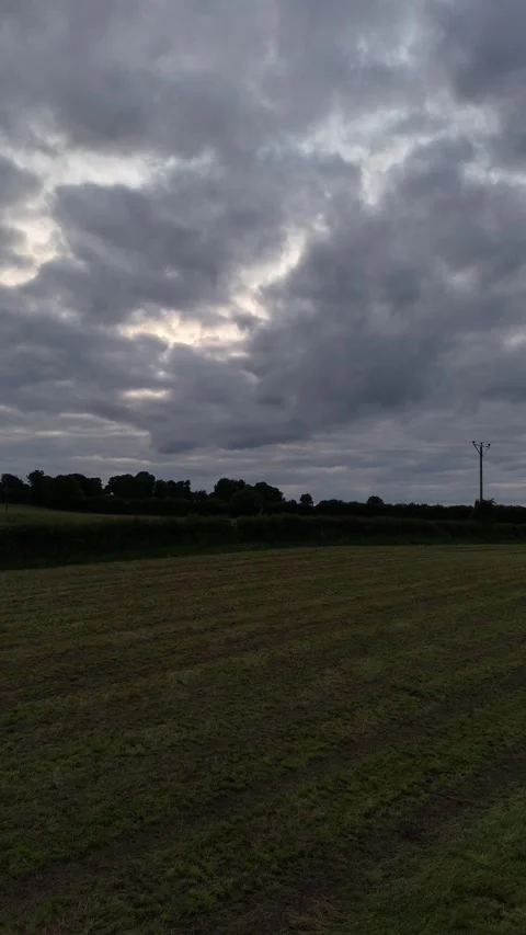 Aerial View of Field at Sunset Under Dramatic Cloudy Sky in 4K Stockbeeldmateriaal 333334007
