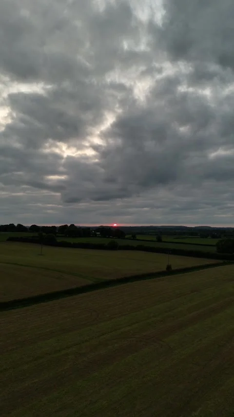 Aerial View of Field at Sunset Under Dramatic Cloudy Sky in 4K 库存影片 333334053