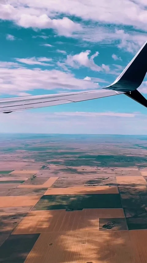 Aerial view of fields from an airplane window during a sunny flight. Stock Footage 342239608