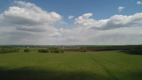 Aerial view of fields and forest of the cloud village of the Siberian landscape Stock Footage 75810959