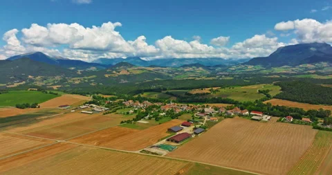Aerial view of fields and sun in the sky with mountains in the background Stock Footage 328101287