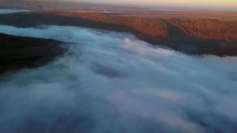 Aerial view of fields on a hill above the clouds Stock Footage 118980735