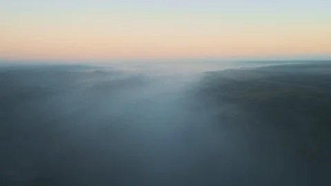 Aerial view of fields underneath layer of clouds. Stock Footage 114442948