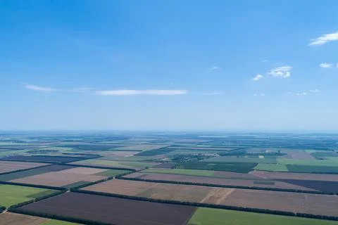 Aerial view of fields with various types of agriculture, against blue sky Stock Photos