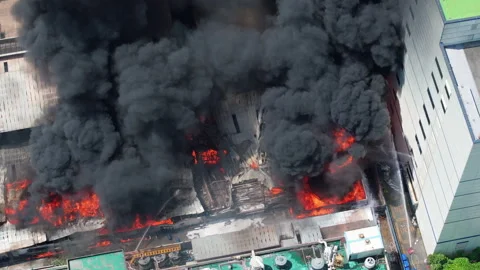 Aerial view of Fire in industrial building. Multi-storey concrete hangar with fl Vidéo 246722445