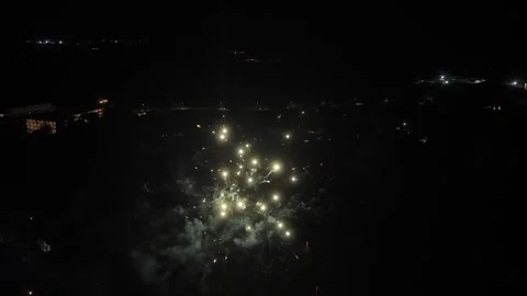 Aerial view of fireworks exploding over town at night 動画素材 328923467