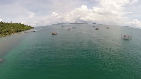 Aerial view of fish cages floating in the middle of the sea on a tropical island Stock Footage 147381510