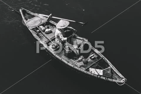 Aerial view of fisherman on circle boat with straw hat