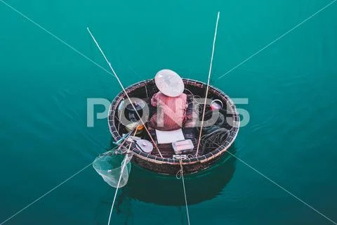 Aerial view of fisherman on circle boat with straw hat