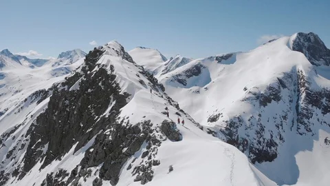 Aerial view of five men on a sharp mountain ridge with skis on back Norway Stock Footage 99738291