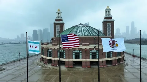 Aerial view of flags on the end of Navy Pier with Chicago skyline on snowy day Stock Footage 231162383