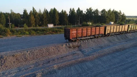 Aerial view. Flight along train of freight cars standing on the rails at sunset. Stock-Footage 94497687