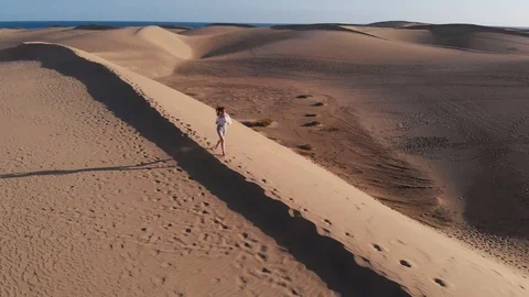 Aerial view - flight of a drone in front of a girl in summer white clothes Stock Footage 113230866