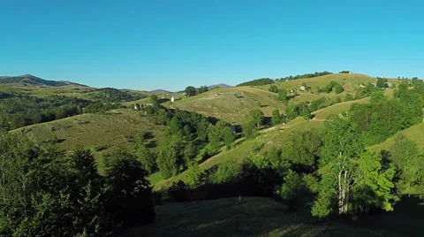 Aerial View, flight over green hills and countryside road and village houses 스톡 동영상 67246916