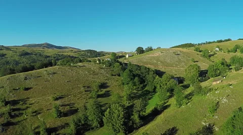 Aerial View, flight over green hills and countryside road and village houses Stockbeeldmateriaal 67247234