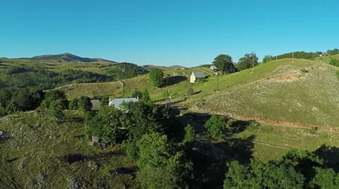 Aerial View, flight over green hills and countryside road and village houses 스톡 동영상 67247408