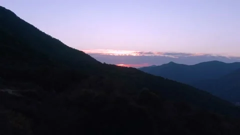 Aerial view flight over the mountains towards a colorful magic sunset. Video stock 141609645