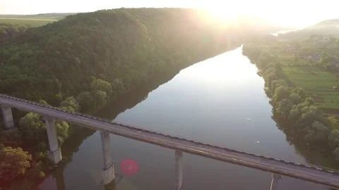 Aerial view. Flight over the river and bridge. Sun dusk. Amazing view green tree Stock Footage 73096037