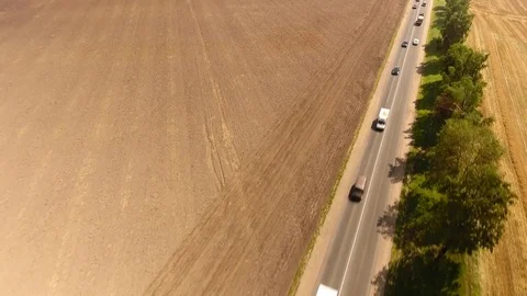 Aerial View. Flight over the road with cars near the fieldt. Aerial drone shot. Stock-Footage 78908537