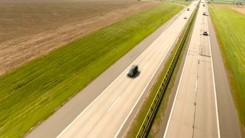 Aerial View. Flight over the road with cars near the fieldt. Aerial drone shot. Stock-Footage 78929128