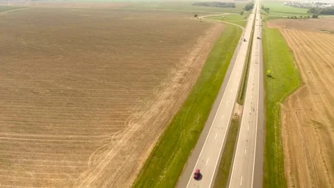 Aerial View. Flight over the road with cars near the fieldt. Aerial drone shot. 動画素材 78931663