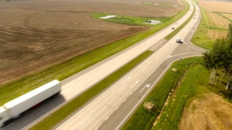 Aerial View. Flight over the road with cars near the fieldt. Aerial drone shot. 動画素材 78966970
