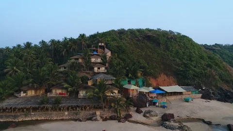 Aerial view. Flight over small tropical hotel bungalow on hillside in jungle. Vídeo Stock 104479930