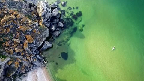 Aerial View: Flight over the сoast. GIrl is swimming in the sea on General Stock Footage 96760864