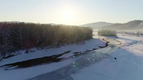 Aerial view: Flight over the winter river and forest. Snow covered trees Stock-Footage 136771023