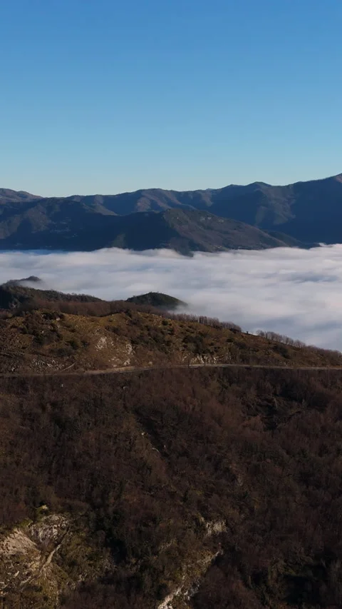 Aerial View of Floating Clouds and Forested Italian Alps Hills at Sunset Stock Footage 334722750