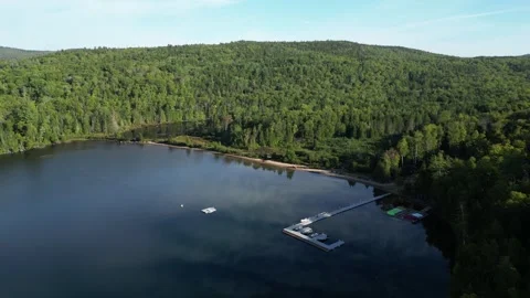 Aerial View of a Floating Dock at a Golden-Lit Lake Beach Stock-Footage 338326607