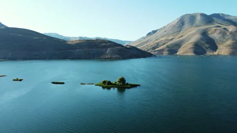 Aerial view of the floating island with trees in the middle of the lake covered Stock Footage 258368929