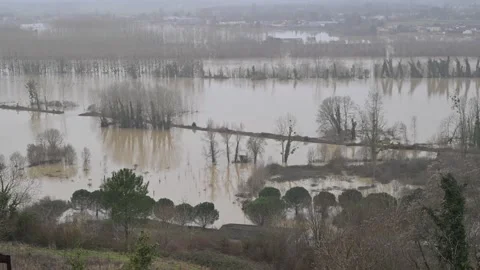 Aerial view of floodwaters engulfing fields and buildings, contrasting the Vídeos de archivo 330986156