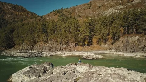 Aerial view flow of the mountain green river Katun. Young girl walking on rocks Stock-Footage 149475147