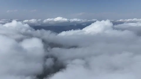 Aerial View of Fluffy Clouds and Blue Sky Over Mountain Landscape Stock Footage 341979705