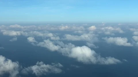 Aerial view of fluffy cloudy sky with an ocean below, serene sunrise Stock Footage 121945801