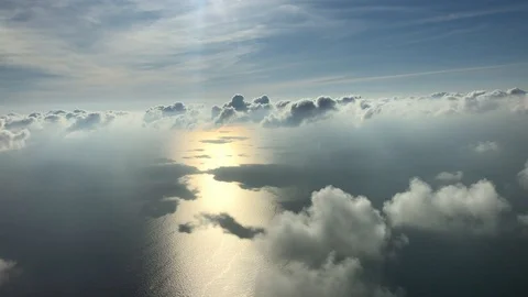 Aerial view of fluffy cloudy sky with an ocean below Stock Footage 121945835