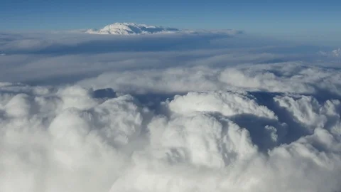 Aerial view of fluffy white clouds from an aircraft window on a sunny day Stock-Footage 92371530