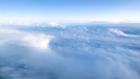 Aerial view of fluffy white clouds and sky from plane window in daylight Stock-Footage 121354858