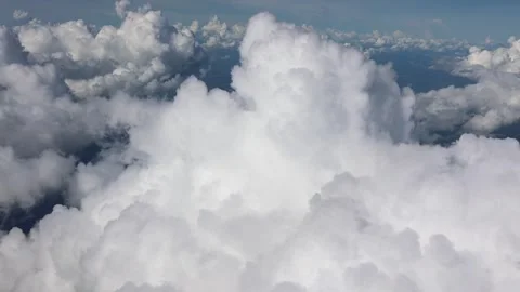 Aerial View of Fluffy White Clouds Floating Above Vast Green Landscapes. Stock Footage 305458939