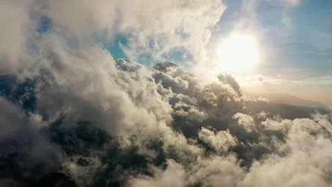 Aerial View of Fluffy White Clouds Flying Over Mountain Peak at Sunny Day Stock Footage 330762853