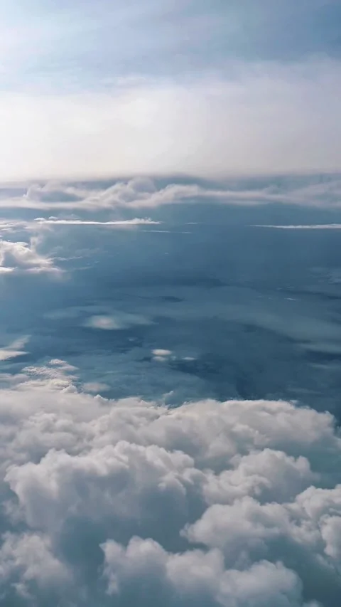 Aerial view of fluffy white clouds from airplane window over the Pacific Ocean Stock Footage 342315578
